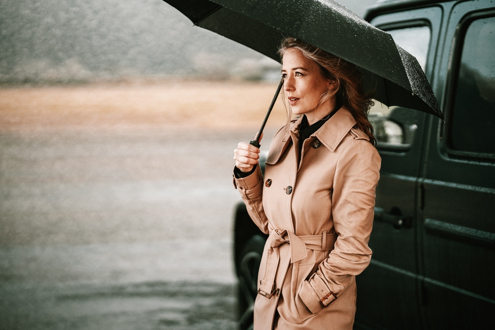 Frau unter schwarzem Regenschirm