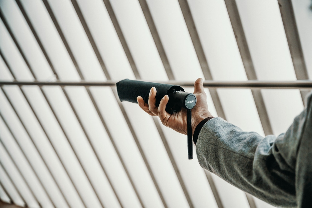 Mann mit Taschenschirm in der Hand Mann mit Taschenschirm in der Hand